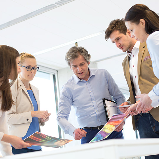 colleagues discussing coloured printouts