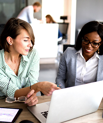 two women working on a laptop