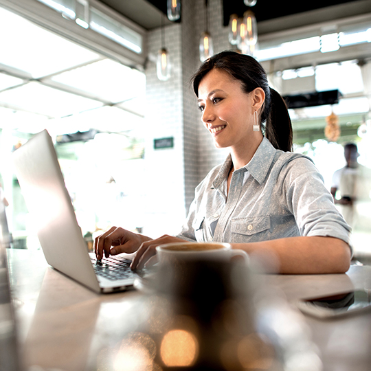 woman typing on computer in cafe